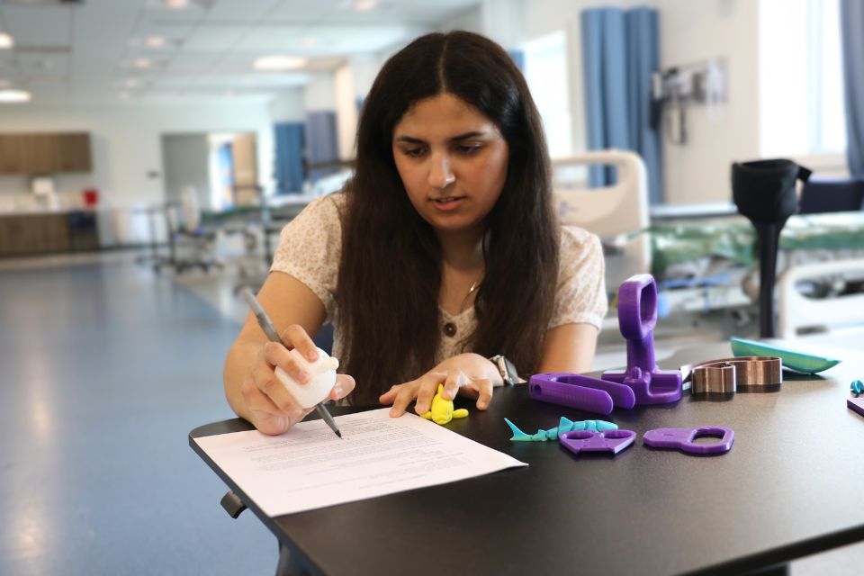 Lydia models the hand writing assistive device.