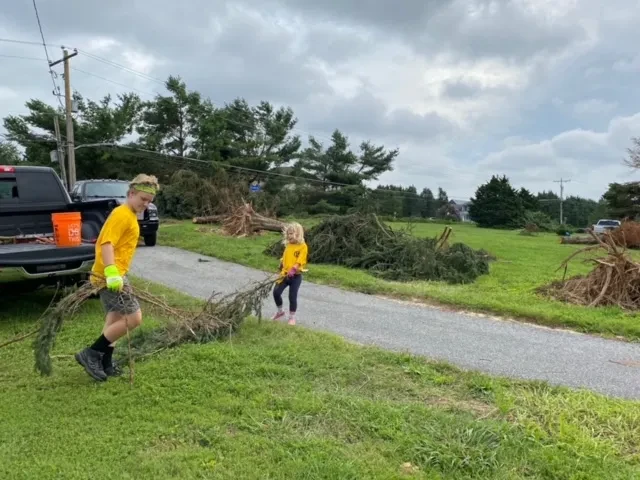 Two of the Schatz children clearing down tree limbs 