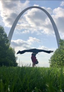 PT grad Rachel Sine does a hand stand split under the St. Louis Gateway Arch.