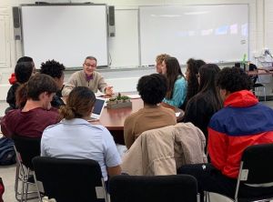 Joseph Meloche talks to people in a circle at a town hall meeting