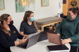 Occupational and physical therapy and speech language pathology students work collaboratively in a learning space on campus.
