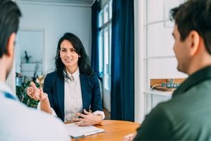 A woman speaks with two men during a business meeting/