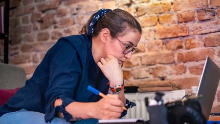 Adult student on laptop taking notes during class