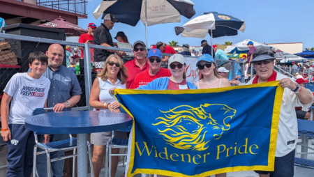 Alumni pose with a Widener Pride banner during Phillies spring training in Florida.