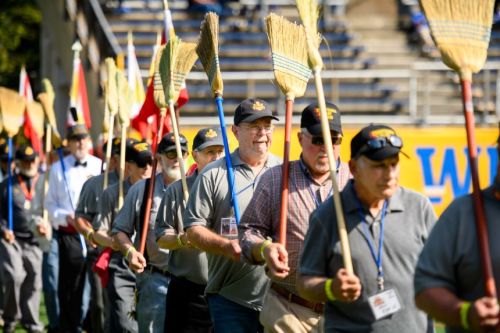 PMC alums entering stadium in a line for the broom drill