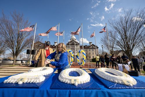 An alumnus and a Widener student cut an oversized cake in the shape of "200" during Founders Day.