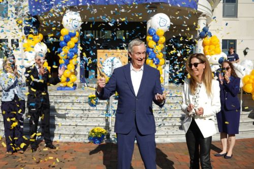 Jack and Nancy Dwyer smile as they cut the ribbon and confetti flies to unveil the Jack &amp; Nancy Dwyer School of Nursing.